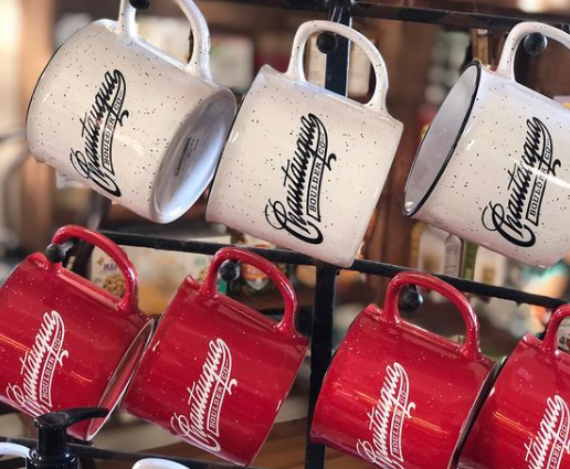Chautauqua branded coffee mugs hanging up in the General Store