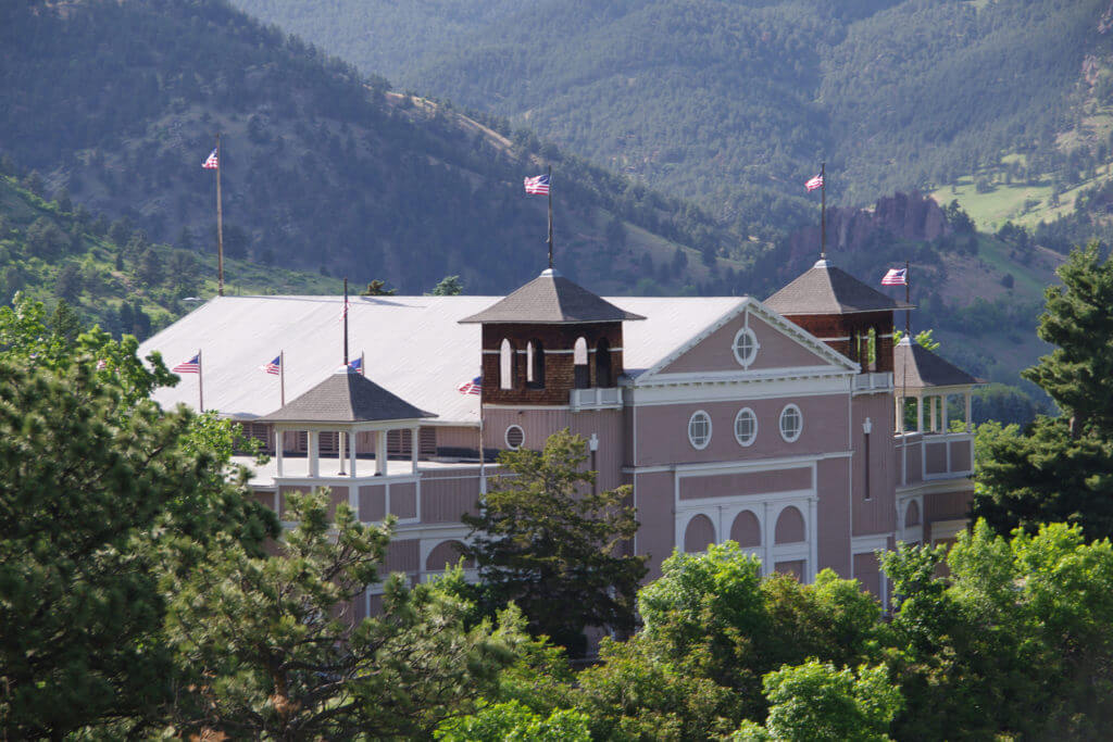 Chautauqua Auditorium surrounded by mountains - with flags flying