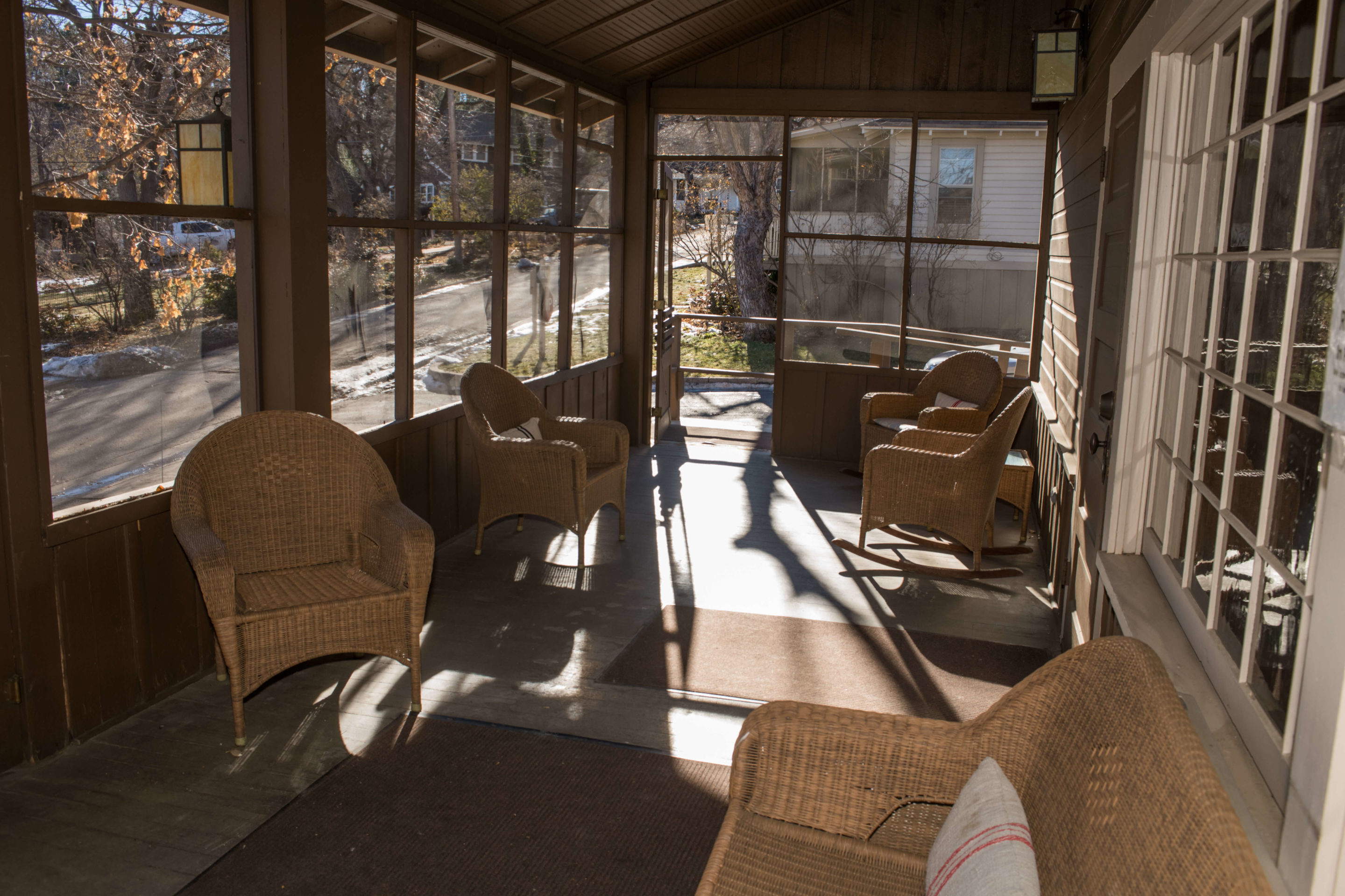 screened-in porch with wicker chairs