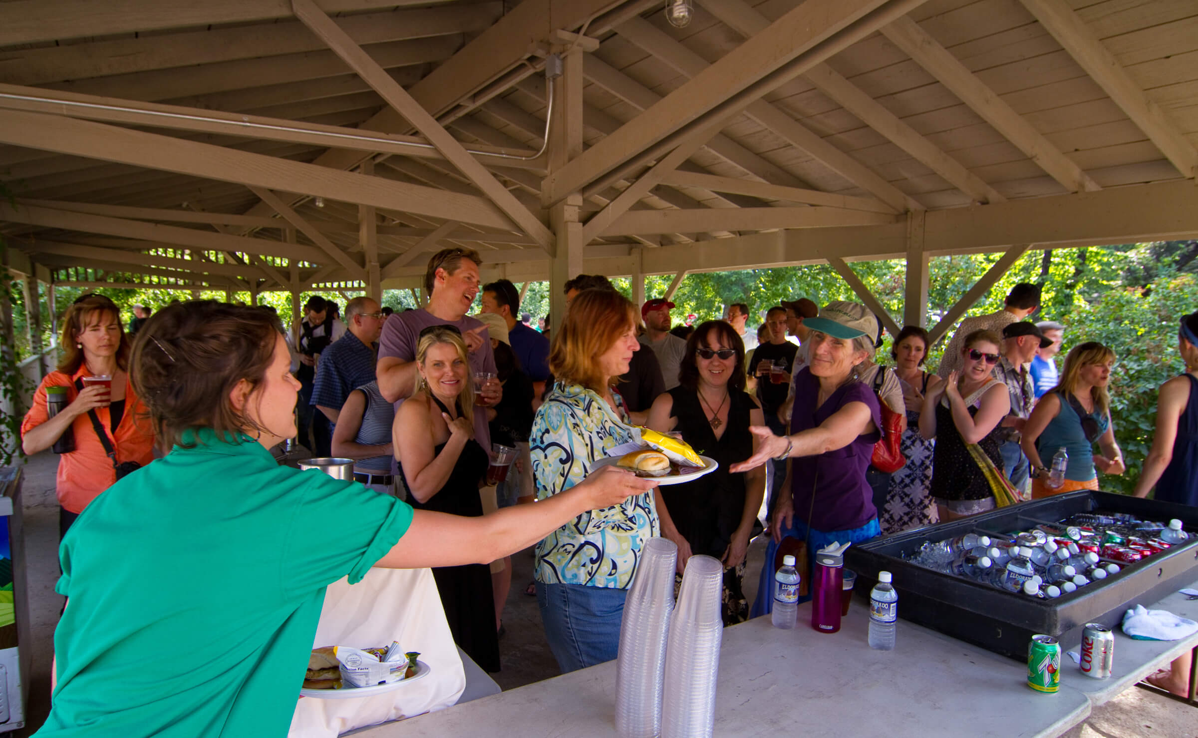 women hands out plate of food in picnic shelter