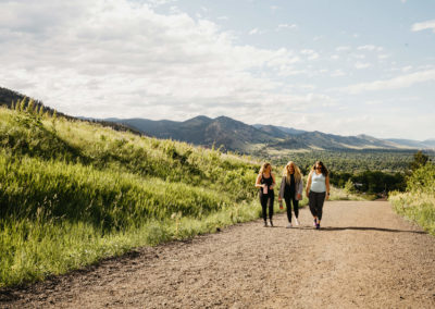 three women hike uphill