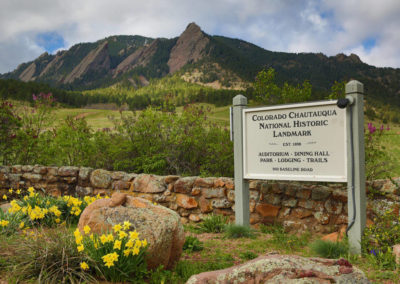 Chautauqua entrance in spring with National Historic Landmark sign and Flatirons behind