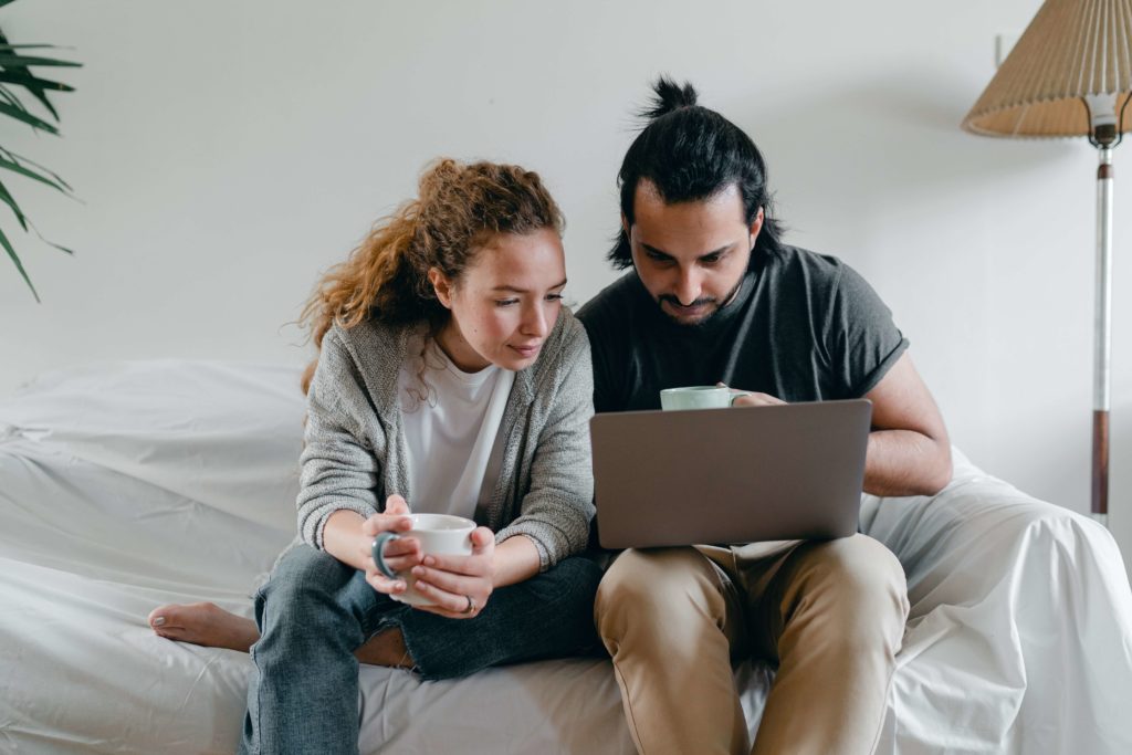 Couple looking at laptop on couch