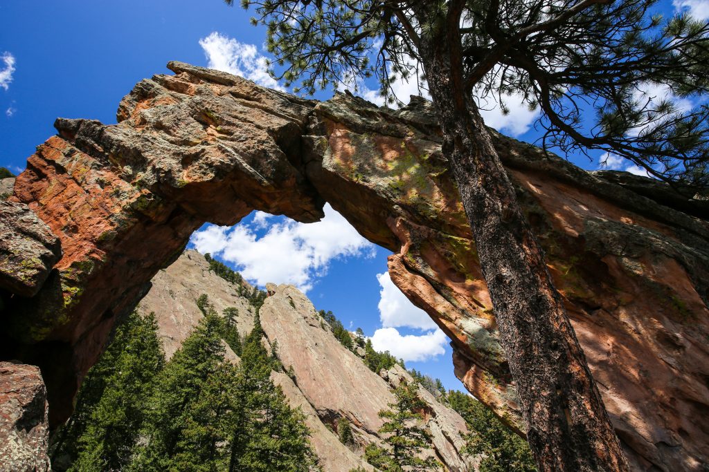 Royal arch rock formation, a large rock arch with trees and a blue sky