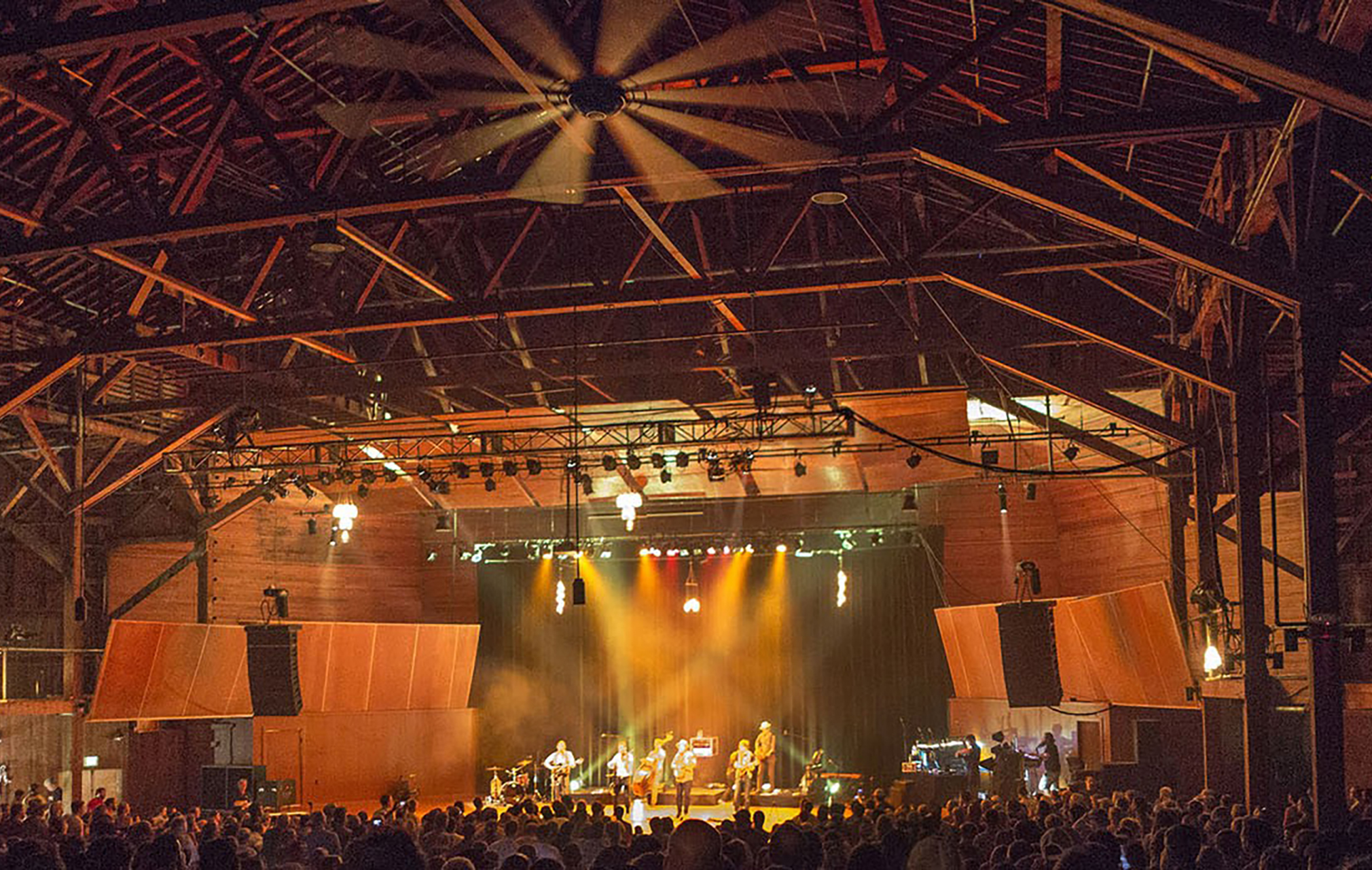 The Chautauqua auditorium during and event, with a large audience in the foreground and a band playing in the center
